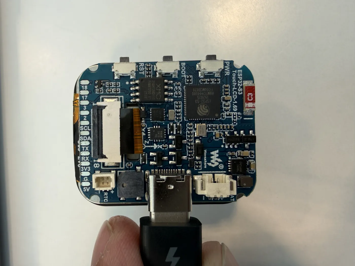Nahaufnahme des unverbauten Waveshare ESP32-S3-Touch-LCD-1.69-Boards mit beschrifteten Pins, ESP32-S3-Chip und angeschlossenem USB-C-Kabel.